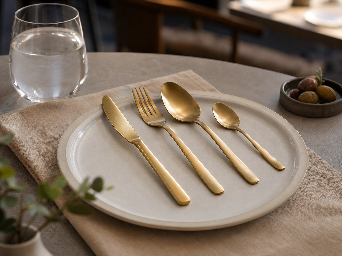 Gold-tone stainless steel flatware in a restaurant table setting