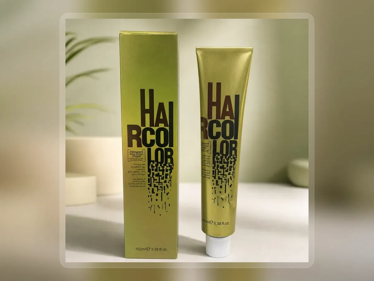 Metallic hair dye tube standing beside green carton on premium extended background