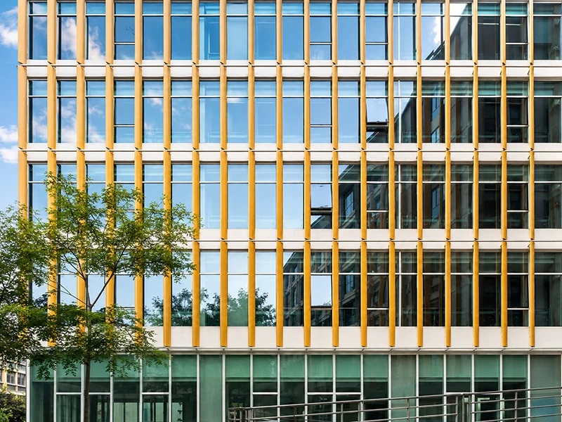 Golden vertical aluminum fins installed across a glazed curtain wall facade