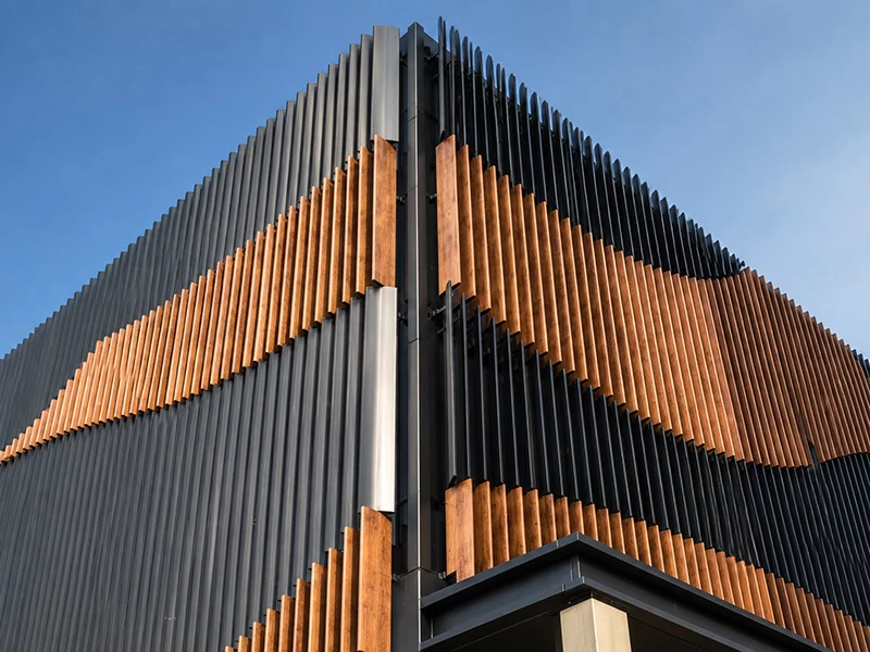 Wood-grain and black vertical aluminum fins on a modern building facade