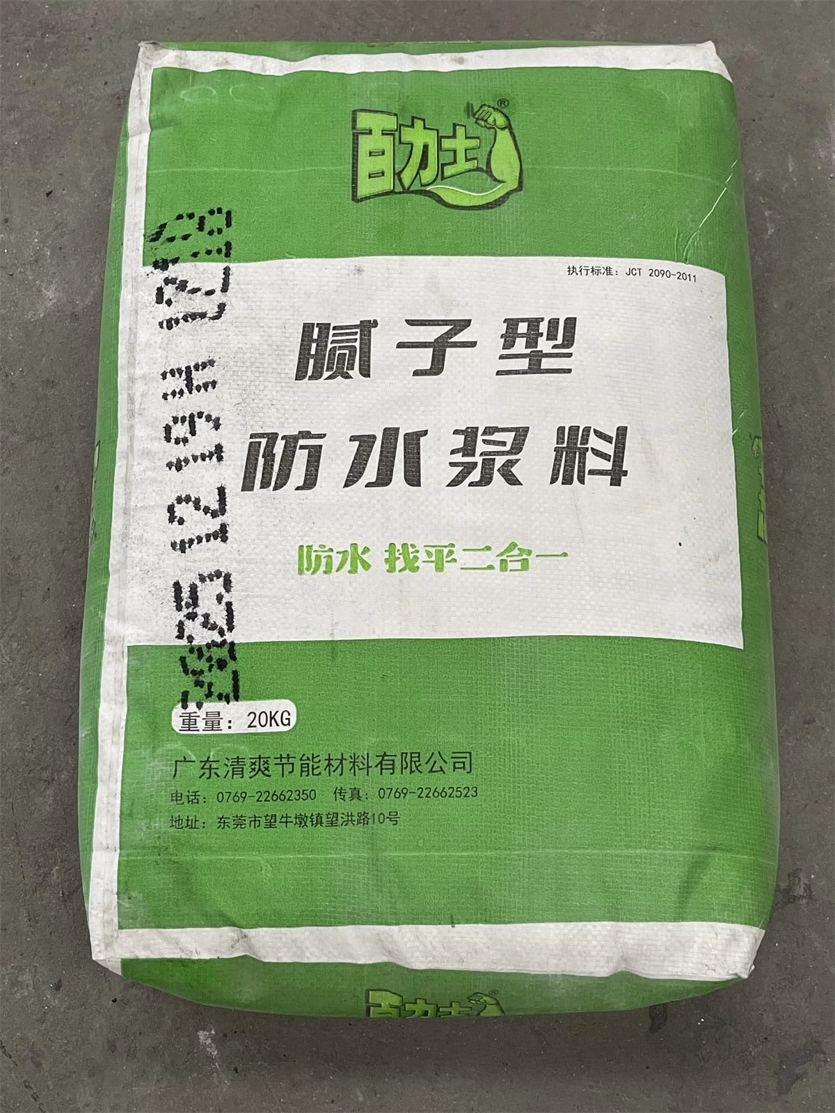 Green bag of waterproof putty slurry photographed on a floor