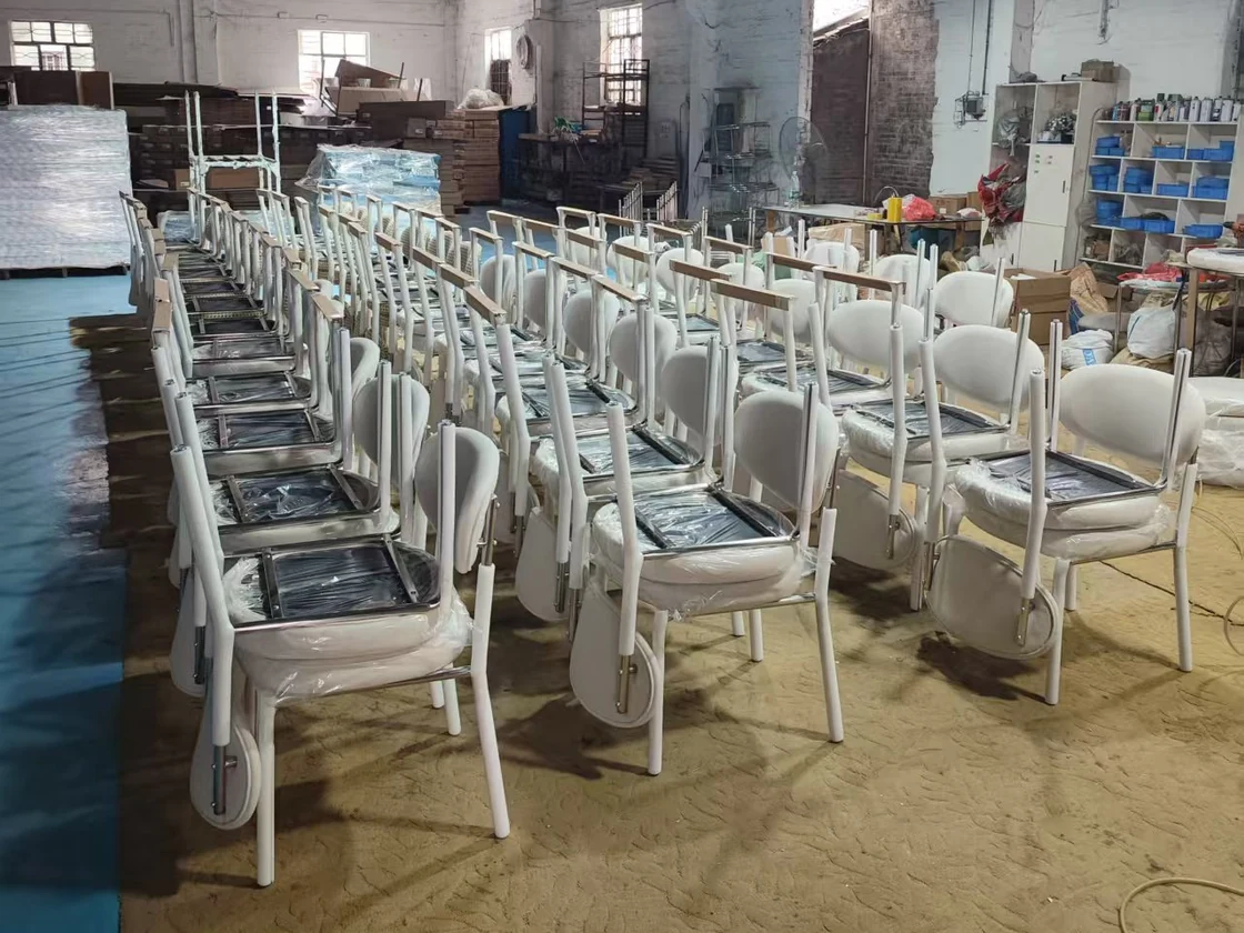 Rows of upholstered dining chairs with wrapping around parts in the workshop
