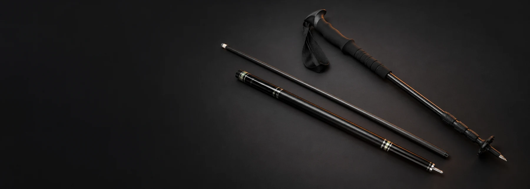 Carbon fiber billiard cues and trekking pole — studio composition